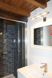 a bathroom with a shower and a sink and a mirror at PINTORES ROOMS Apartamentos Turísticos in Cáceres