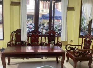 a table and chairs in a room with a window at Leng Saysana Guesthouse in Vang Vieng