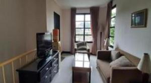 ein Wohnzimmer mit Fernseher und Sofa in der Unterkunft Casa D' Ladera Hotel in Bandung