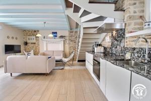 吉代勒La mesange bleue的厨房以及带沙发和水槽的起居室。