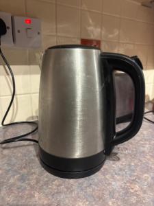 a black and silver mug sitting on a counter at OakHouse- Entire 3 Bedroom Terrace House with Free Parking in Cumbernauld +25 photos
