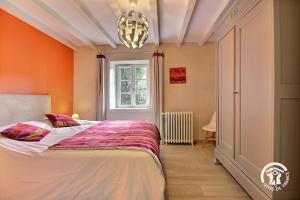 吉代勒La mesange bleue的一间有橙色墙壁的卧室，有一张床和一扇窗户