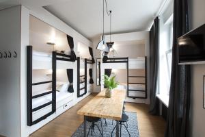 a room with two bunk beds and a wooden table at Pyjama Park Schanzenviertel in Hamburg