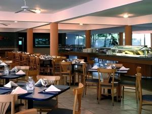 a restaurant with tables and chairs and a bar at Celuisma Playa Dorada All Inclusive in Sampiño