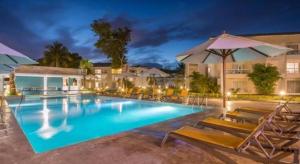 a large swimming pool with chairs and umbrellas at Celuisma Playa Dorada All Inclusive in Sampiño