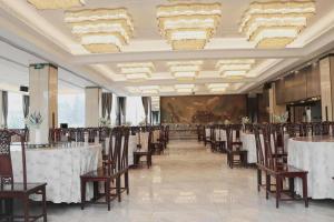 FeichengにあるFeicheng Blossom Hotelの宴会場(テーブル、椅子、シャンデリア付)