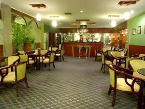 a restaurant with tables and chairs and a bar at New Friendship Hotel in Luoyang