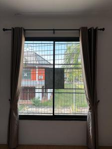 a window with a view of a building at Two Sisters Suratthani in Ban Don Rak