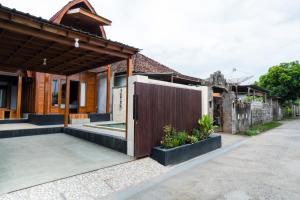 une maison avec une porte en bois devant elle dans l'établissement Villa Aditya, à Babakan Sangsit