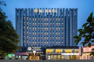 a tall building with a sign on top of it at Jinjiang Metropolo Hotel - Taizhou Wanda Plaza in Taizhou