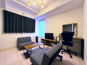 a living room with a couch and a desk with a computer at Excel 平岸B -FIX HOME- in Sapporo