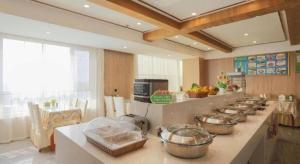 a kitchen with a row of bowls on a counter at GreenTree Inn Express Laizhou Bus Station Wenhua Xi Street in Laizhou