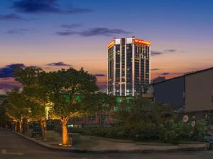 ein hohes Gebäude mit roten Lichtern darüber in der Unterkunft Vienna Hotel Guiyang Jiaxiulou Jichang Road in Guiyang