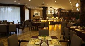 ein Speisesaal mit Tischen und Stühlen in einem Restaurant in der Unterkunft Excemon Beach Hotel Beihai in Beihai