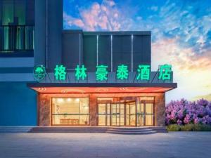 a building with a sign on the front of it at GreenTree Inn Haixi Geermu Southern suburbs Express Hotel in Golmud