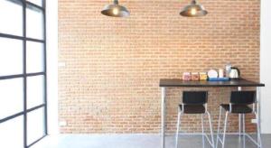 a brick wall with a table and two bar stools at L22 HOSTEL in Ban Khlong Samrong
