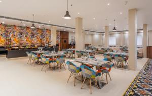 a dining room with tables and chairs in a building at Zone Connect by The Park Patna 