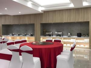 ein Konferenzraum mit einem roten Tisch und weißen Stühlen in der Unterkunft Mercure Styles Hotel Meizhou in Meizhou + 91 Fotos