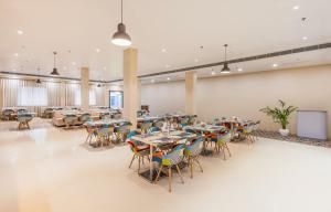 a cafeteria with tables and chairs in a room at Zone Connect by The Park Patna  +63 photos