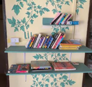 a book shelf with books on it next to a wall at Leng Saysana Guesthouse in Vang Vieng