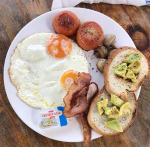 a plate of breakfast food with eggs bacon potatoes and mushrooms at Koh Rong Lagoon in Koh Rong Island +4 photos