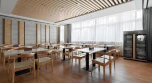 a dining room with tables and chairs and windows at GreenTree Inn Wuhu Eshan Road University City in Wuhu