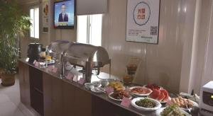 a buffet with food on a counter in a restaurant at Shell Baoding Dongfeng Middle Road Kailian Hotel in Baoding