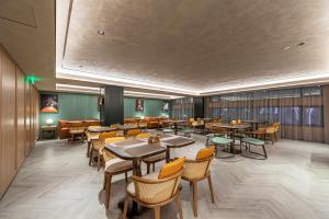 un ristorante con tavoli e sedie in una stanza di Orange Hotel Shanghai Meilong Wanhui International Plaza a Shanghai Altre 26 foto