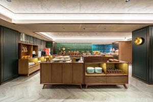 un ristorante con bancone e cibo in esposizione di Orange Hotel Shanghai Meilong Wanhui International Plaza a Shanghai