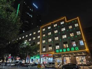a large building with green lights in front of it at GreenTree Inn Ganzhou Gan County Bus Station in Meilin