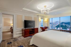 a bedroom with a large bed and a flat screen tv at Kempinski Hotel Guiyang in Guiyang +90 photos