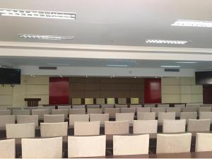 an empty lecture hall with white chairs and a screen at GreenTree Inn Rizhao Yantai Road in Rizhao