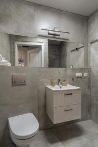 a bathroom with a toilet and a sink and a mirror at Kazimierz Residence Apartments Parking - by Staymoovers in Krakow