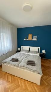 Un dormitorio con una cama grande con una pared azul. en Vanjkuš, en Marija Bistrica