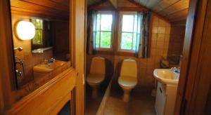 a bathroom with two toilets and a sink at Hotelli Luostarin Puutarha in Naantali