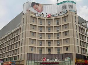 a building with a billboard of a man on it at Jinjiang Inn Linyi Jinqueshan Road Branch in Linyi