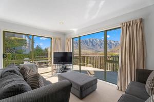 un salon avec un canapé et une télévision dans l'établissement Marina Heights, à Queenstown