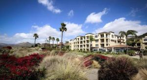 ein großes Apartmenthaus mit Palmen und Blumen in der Unterkunft Dolphin Bay Resort and Spa in Shell Beach