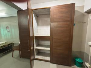 une salle de bains avec un placard en bois à étagères dans l'établissement SATVIK STAy, à Navi Mumbai 2 autres photos