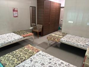 une salle d'hôpital avec trois lits et une chaise dans l'établissement SATVIK STAy, à Navi Mumbai