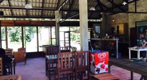 a dining room with tables and chairs and windows at Chiang Dao Hut in Ban Tham