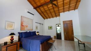 a bedroom with a bed with blue sheets and a desk at Villa Blue Lotus Katunayake in Katunayake +28 photos