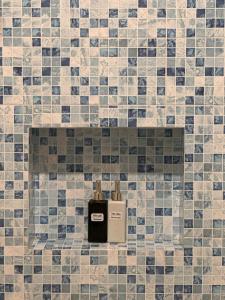 a bathroom with a soap dispenser on a tiled wall at HOLIDAY HOTEL PHAN THiẾT in Ấp Bình Hưng +92 photos
