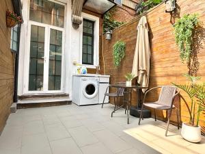 eine Terrasse mit Waschmaschine und einem Tisch mit Stühlen in der Unterkunft Private Garden Courtyard in Shanghai Old Villa Near City Center Nanjing West Road Metro Station in Shanghai