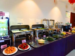 a buffet line with many different types of food at GreenTree Inn Shandong Yantai Penglai Pavilion Bus station Express Hotel in Penglai