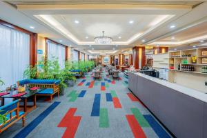 a restaurant with colorful floors and tables and chairs at Ramada Beijing North in Changping