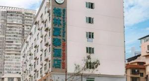 a white building with a clock on the side of it at GreenTree Inn Nanning Langdong Hotel in Nanning