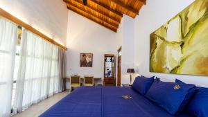 a bedroom with a blue bed and a table at Villa Blue Lotus Katunayake in Katunayake