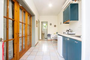 a kitchen with blue cabinets and a tile floor at Rigos Apartments in Vitalades