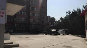 Dos coches estacionados en un estacionamiento frente a un edificio. en Jinjiang Inn Handan Zhonghua Nan Street Xueyuan Bei Road, en Handan